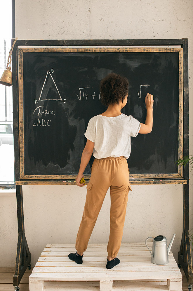 Math Fundamentals Support, image of young girl doing math on a chalkboard