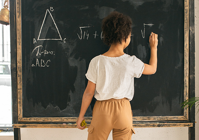 Math Fundamentals Support in San Diego, image of young girl doing math on a chalkboard