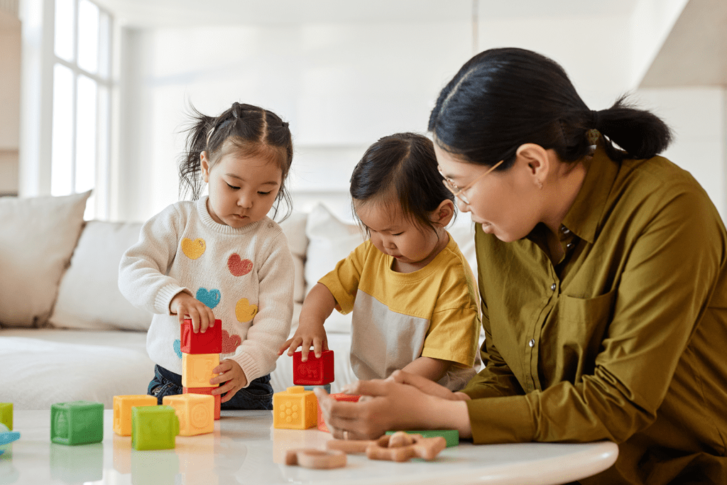 Executive Functioning Skills by Age: A Comprehensive Guide for Parents, image of mom with two young kids building blocks