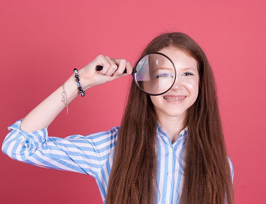 Program Benefits, image of a young girl with a magnifying glass