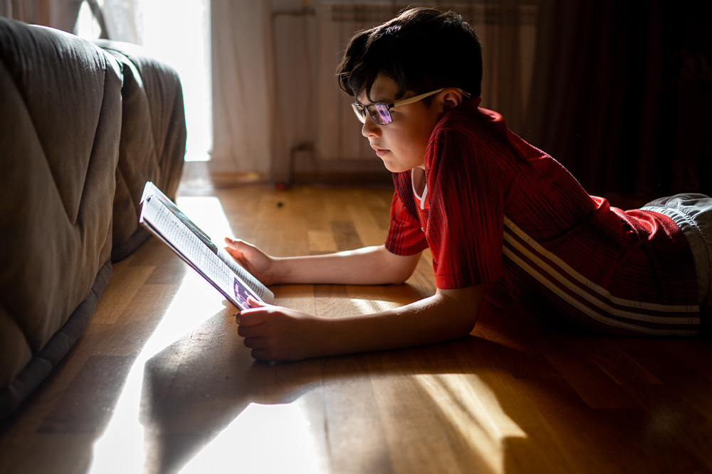 Reading Comprehension for Autism: Turning Words into Meaning, image of boy reading on floor.