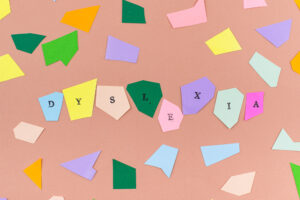 how to help a child with dyslexia at home, image of Dyslexia spelled on cut out paper on the table.